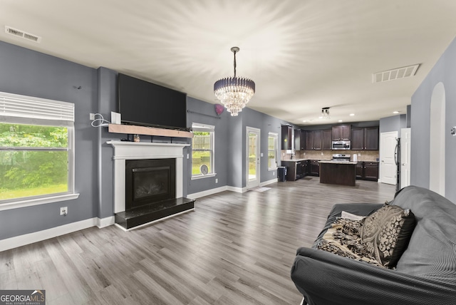 240 Somerset Dr, Dallas, GA 30132 - living room featuring a chandelier, wood finished floors, baseboards, a glass covered fireplace, and recessed lighting