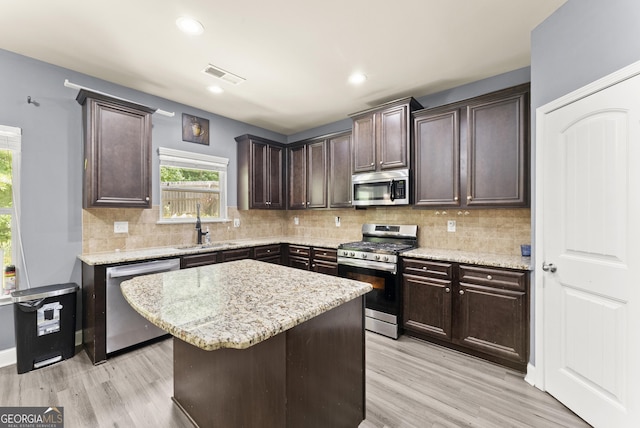 240 Somerset Dr, Dallas, GA 30132 - kitchen with appliances with stainless steel finishes, light wood-style floors, dark brown cabinets, backsplash, and recessed lighting