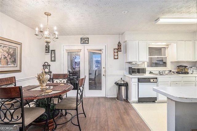 3244 Hampton Ct, Smyrna, GA 30082 - kitchen with dishwasher, a textured ceiling, stainless steel microwave, wood finished floors, and light countertops
