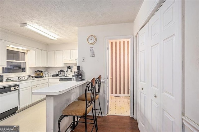 3244 Hampton Ct, Smyrna, GA 30082 - kitchen with dishwasher, a kitchen breakfast bar, white cabinets, under cabinet range hood, and a textured ceiling