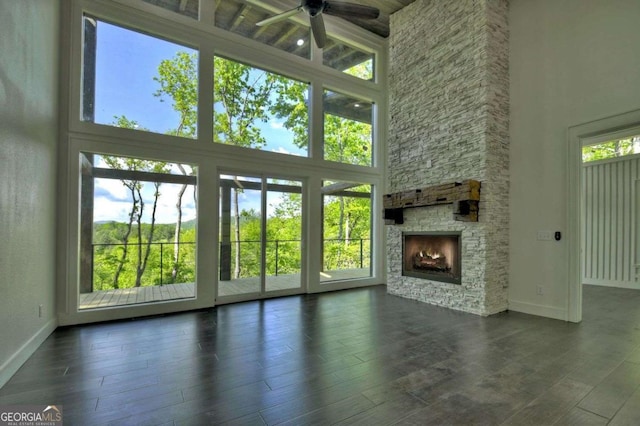 840 Arp Rd, Mineral Bluff, GA 30559 - unfurnished living room with a high ceiling, ceiling fan, baseboards, a fireplace, and dark wood-style floors