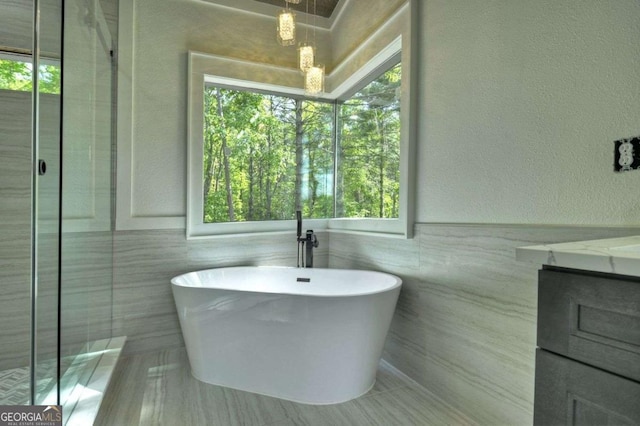 840 Arp Rd, Mineral Bluff, GA 30559 - bathroom with a freestanding bath, plenty of natural light, vanity, a textured wall, and tile walls