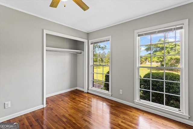 315 Burke Cir, Mcdonough, GA 30253 - unfurnished bedroom featuring crown molding, wood finished floors, multiple windows, baseboards, and a closet