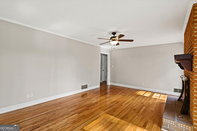 315 Burke Cir, Mcdonough, GA 30253 - unfurnished living room featuring a ceiling fan, wood finished floors, baseboards, ornamental molding, and a brick fireplace