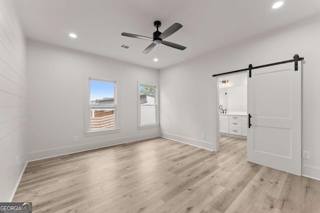 396 Forrest Ave, Gainesville, GA 30501 - unfurnished bedroom with a barn door, light wood-type flooring, recessed lighting, baseboards, and ceiling fan