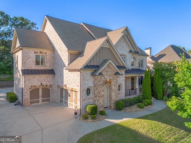 2604 Heltonwood Ct, Buford, GA 30519 - view of front of home featuring driveway, a standing seam roof, an attached garage, a front lawn, and board and batten siding
