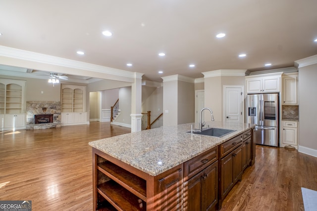 2604 Heltonwood Ct, Buford, GA 30519 - kitchen with stainless steel fridge with ice dispenser, ornamental molding, a sink, a kitchen island with sink, and a fireplace