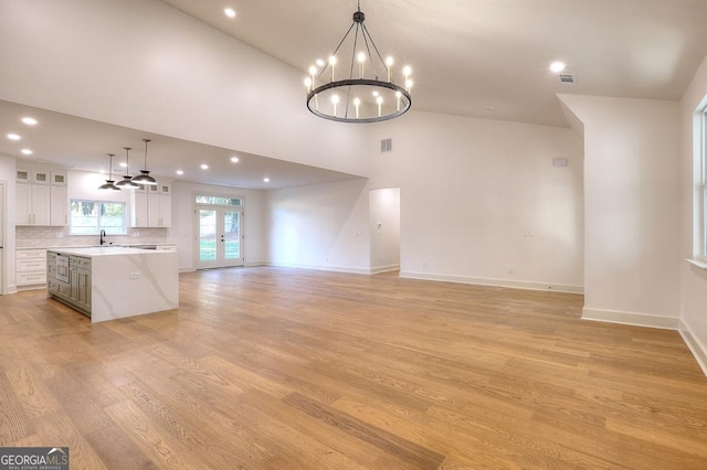 1947 Clark Dr, Tucker, GA 30084 - unfurnished living room featuring a chandelier, light wood-style floors, a sink, recessed lighting, and a high ceiling
