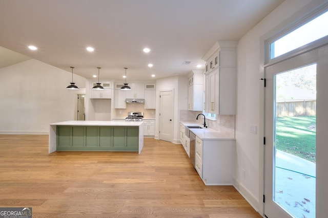 1947 Clark Dr, Tucker, GA 30084 - kitchen with stainless steel range oven, a kitchen island, under cabinet range hood, decorative backsplash, and white cabinetry