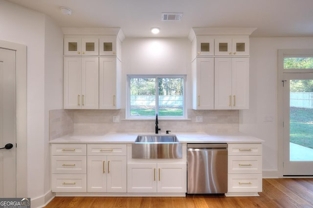 1947 Clark Dr, Tucker, GA 30084 - kitchen with stainless steel dishwasher, a sink, light countertops, backsplash, and white cabinetry