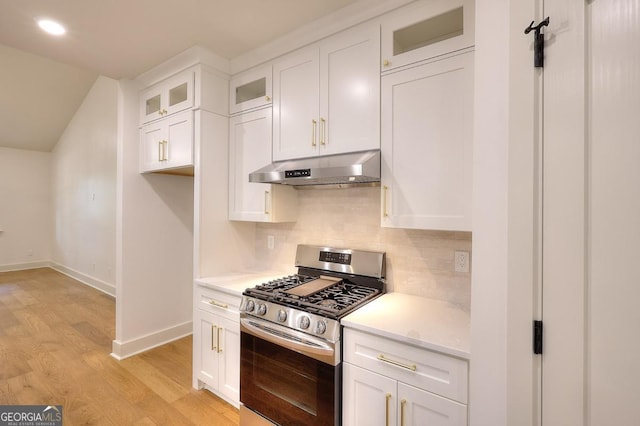 1947 Clark Dr, Tucker, GA 30084 - kitchen featuring under cabinet range hood, gas stove, light wood-type flooring, decorative backsplash, and white cabinets