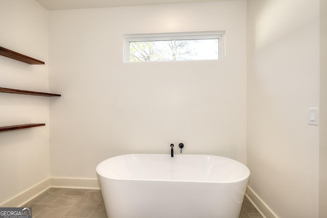 1947 Clark Dr, Tucker, GA 30084 - bathroom featuring a freestanding tub, baseboards, and tile patterned floors