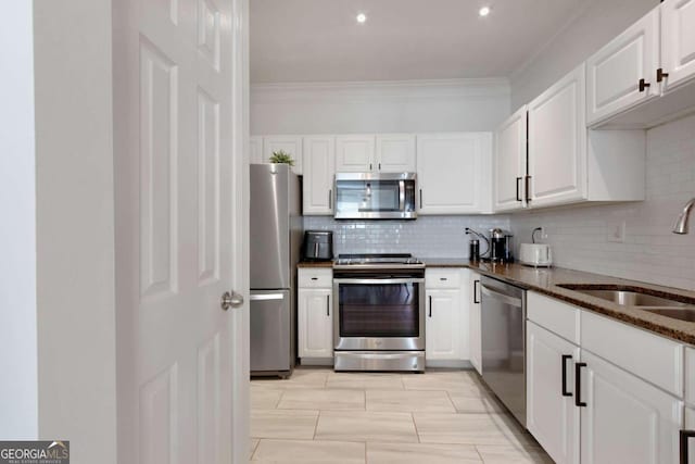 1850 Cotillion Dr Unit 2304, Atlanta, GA 30338 - kitchen featuring appliances with stainless steel finishes, a sink, white cabinetry, decorative backsplash, and ornamental molding