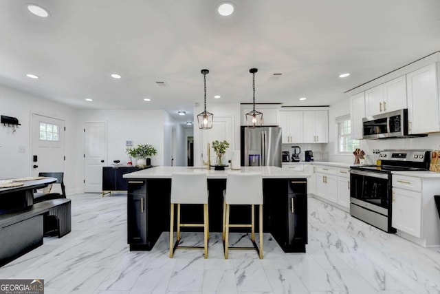 3799 Sweetbriar Cir, Lithia Springs, GA 30122 - kitchen with stainless steel appliances, plenty of natural light, a kitchen island with sink, light countertops, and recessed lighting