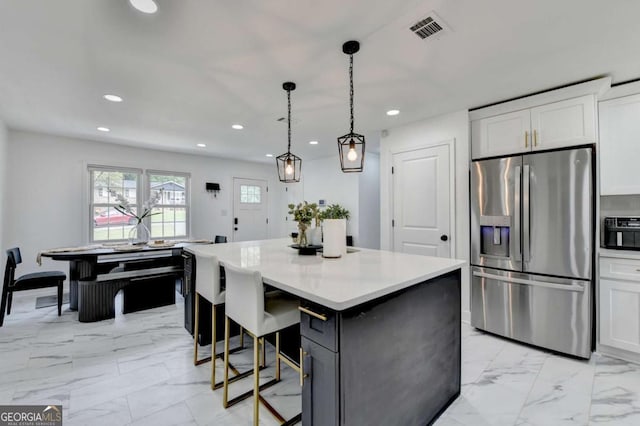 3799 Sweetbriar Cir, Lithia Springs, GA 30122 - kitchen with stainless steel fridge, light marble finish floors, recessed lighting, white cabinets, and a kitchen island