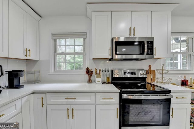3799 Sweetbriar Cir, Lithia Springs, GA 30122 - kitchen with stainless steel appliances, white cabinetry, tasteful backsplash, and light countertops