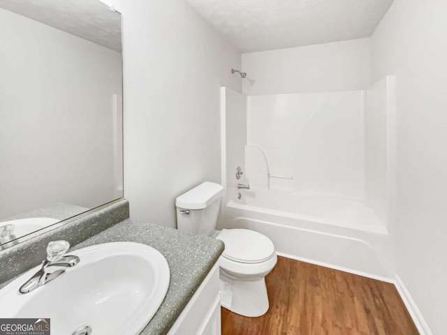 4311 Marci St, Snellville, GA 30039 - bathroom with wood finished floors, tub / shower combination, vanity, toilet, and a textured ceiling