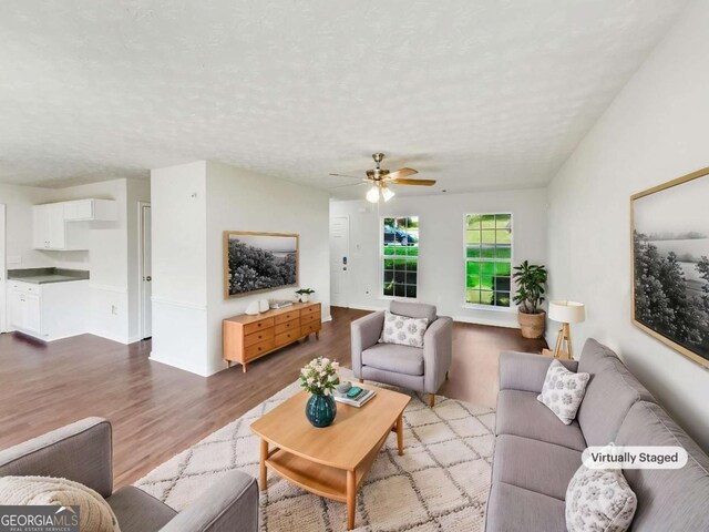 4311 Marci St, Snellville, GA 30039 - living area featuring wood finished floors, a ceiling fan, and a textured ceiling