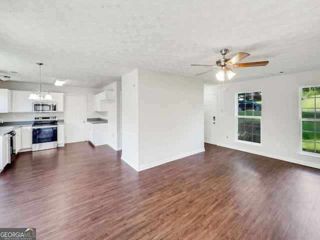 4311 Marci St, Snellville, GA 30039 - unfurnished living room featuring dark wood-style floors, a ceiling fan, baseboards, a chandelier, and a textured ceiling