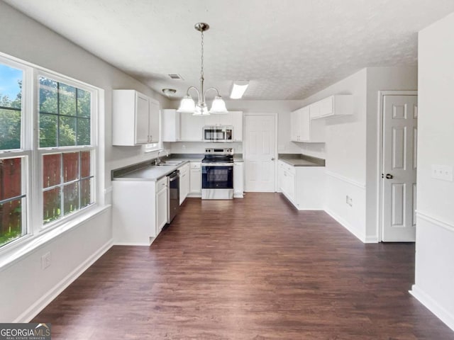 4311 Marci St, Snellville, GA 30039 - kitchen featuring appliances with stainless steel finishes, dark wood finished floors, baseboards, a chandelier, and a sink