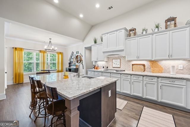 21 Little Creek Dr, Monroe, GA 30655 - kitchen featuring vaulted ceiling, white cabinetry, an island with sink, a breakfast bar, and a chandelier