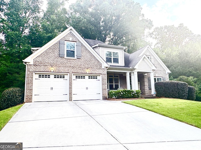 1761 Turtle Pond Dr, Watkinsville, GA 30677 - view of front facade featuring brick siding, a front yard, driveway, a garage, and covered porch