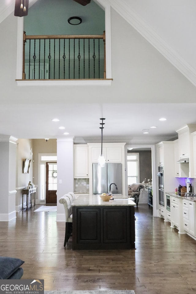 1761 Turtle Pond Dr, Watkinsville, GA 30677 - kitchen featuring stainless steel appliances, high vaulted ceiling, healthy amount of natural light, white cabinets, and crown molding