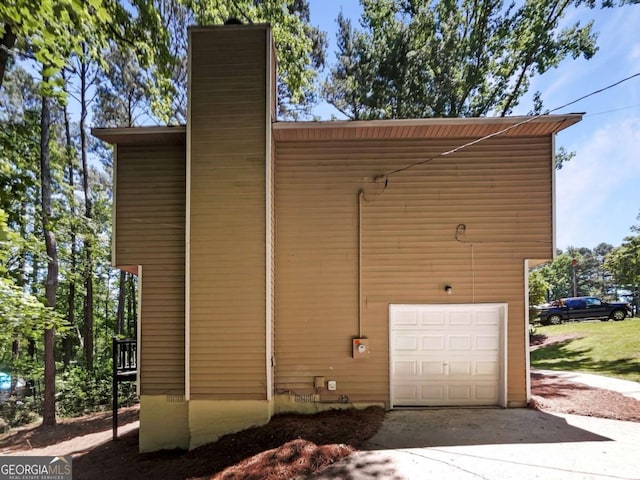 3924 Chimney Ridge Ct, Ellenwood, GA 30294 - view of home's exterior featuring a chimney, an attached garage, and concrete driveway