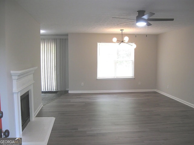 4383 Chestnut Lake Ave, Lithonia, GA 30038 - unfurnished living room with a chandelier, a ceiling fan, dark wood-style flooring, baseboards, and a fireplace with raised hearth