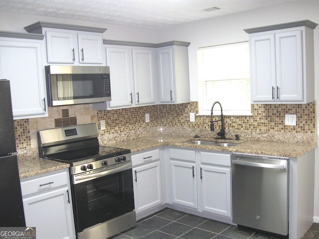 4383 Chestnut Lake Ave, Lithonia, GA 30038 - kitchen featuring stainless steel appliances, a sink, decorative backsplash, and light stone counters