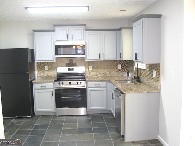 4383 Chestnut Lake Ave, Lithonia, GA 30038 - kitchen featuring appliances with stainless steel finishes, a sink, decorative backsplash, and light stone countertops
