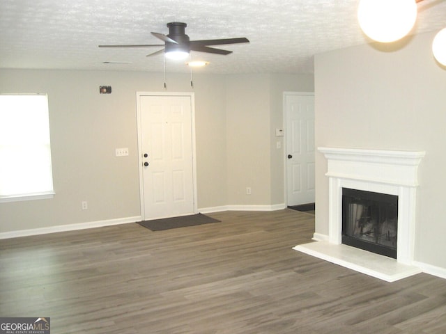 4383 Chestnut Lake Ave, Lithonia, GA 30038 - unfurnished living room with ceiling fan, wood finished floors, a textured ceiling, and a fireplace with raised hearth