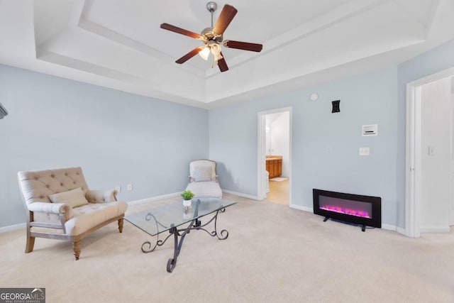 2584 Grayton Loop, Villa Rica, GA 30180 - living area with a tray ceiling, carpet floors, a ceiling fan, baseboards, and a glass covered fireplace