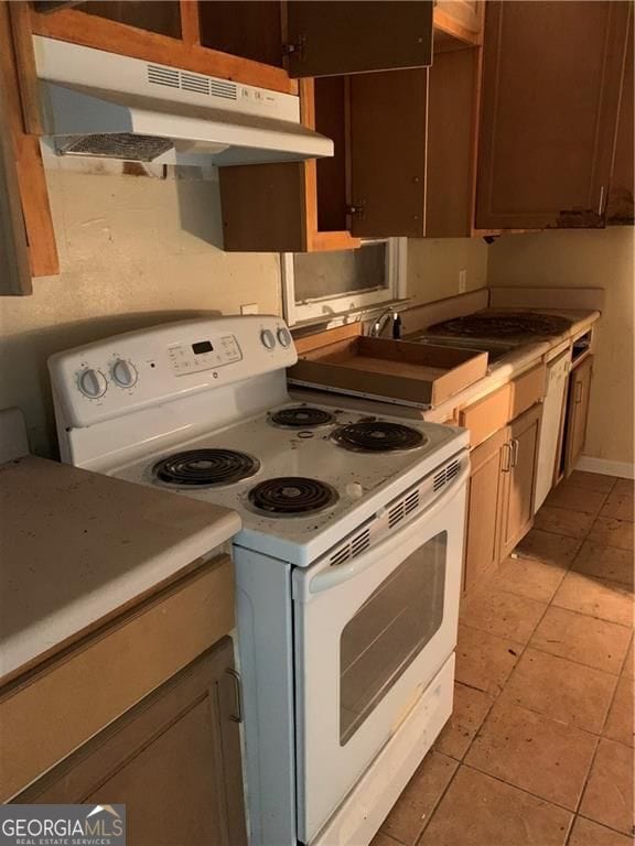 449 Hamilton E Holmes Dr NW, Atlanta, GA 30318 - kitchen with electric range, under cabinet range hood, light tile patterned floors, and light countertops