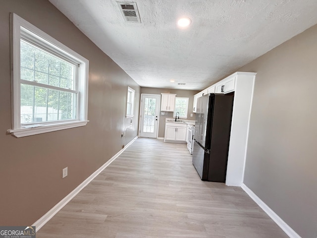 1502 12th St, Augusta, GA 30901 - kitchen featuring freestanding refrigerator, a sink, a textured ceiling, baseboards, and light wood-style floors