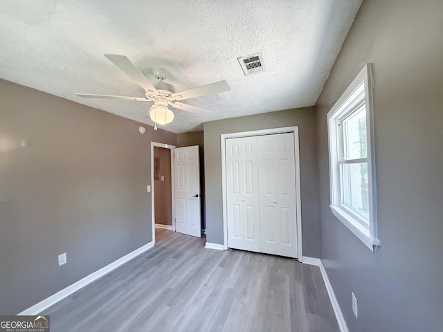 1502 12th St, Augusta, GA 30901 - unfurnished bedroom with baseboards, wood finished floors, a closet, a textured ceiling, and ceiling fan