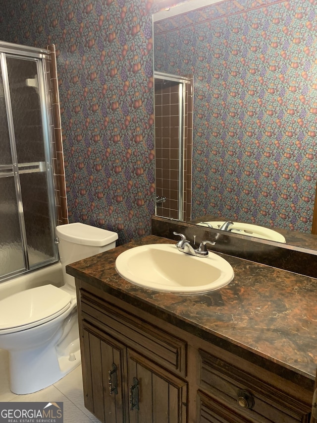 2242 Oakgrove Cir, Valdosta, GA 31602 - full bathroom featuring wallpapered walls, vanity, toilet, tile patterned floors, and bath / shower combo with glass door