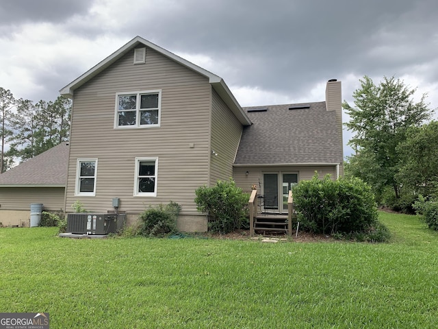 2242 Oakgrove Cir, Valdosta, GA 31602 - rear view of house featuring a yard, a chimney, cooling unit, and a shingled roof