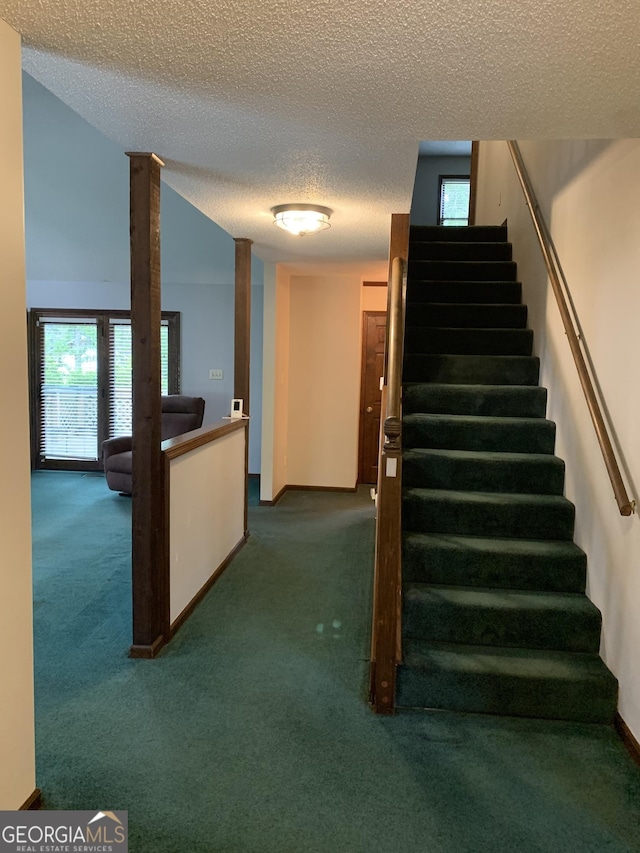 2242 Oakgrove Cir, Valdosta, GA 31602 - staircase featuring a textured ceiling, carpet flooring, and plenty of natural light