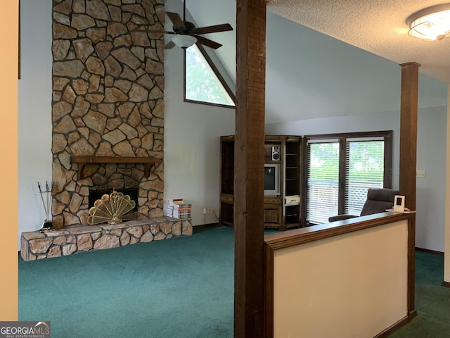 2242 Oakgrove Cir, Valdosta, GA 31602 - carpeted living area with a stone fireplace, lofted ceiling, a ceiling fan, and a textured ceiling