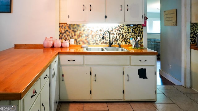 16156 Barnesville St, Zebulon, GA 30295 - kitchen with a sink, tasteful backsplash, dishwasher, light tile patterned floors, and white cabinets