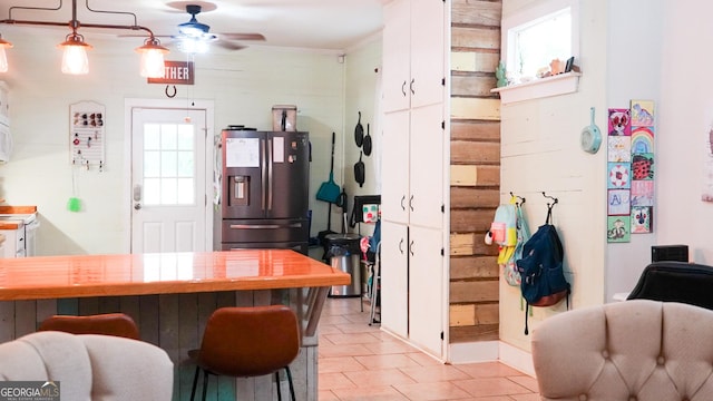 16156 Barnesville St, Zebulon, GA 30295 - kitchen featuring stainless steel fridge with ice dispenser, a ceiling fan, white cabinets, light tile patterned floors, and a kitchen bar