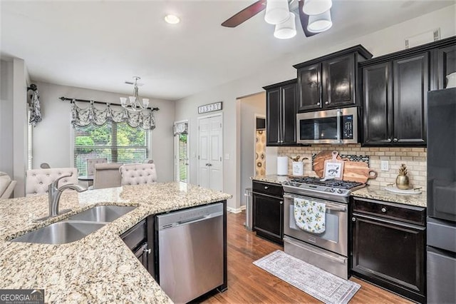230 Haleys Ct, Woodstock, GA 30188 - kitchen with appliances with stainless steel finishes, a chandelier, dark cabinets, a sink, and light wood-style floors