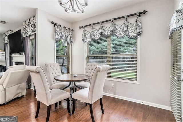 230 Haleys Ct, Woodstock, GA 30188 - dining area with a chandelier, baseboards, wood finished floors, and a fireplace