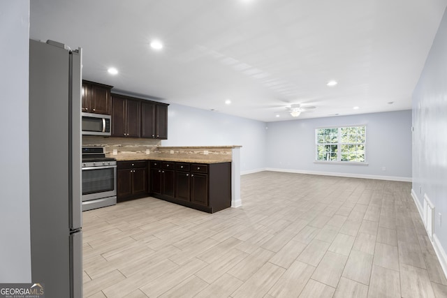 2067 Kinridge Ct, Marietta, GA 30062 - kitchen featuring stainless steel appliances, a ceiling fan, dark brown cabinetry, baseboards, and open floor plan