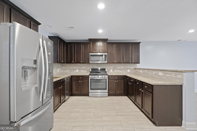 2067 Kinridge Ct, Marietta, GA 30062 - kitchen featuring stainless steel appliances, a peninsula, tasteful backsplash, dark brown cabinetry, and light stone countertops