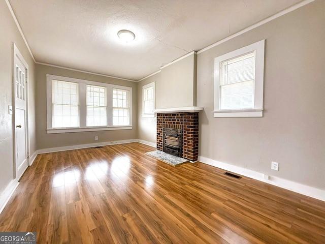 132 Carey St, Elberton, GA 30635 - unfurnished living room featuring crown molding, wood finished floors, plenty of natural light, a brick fireplace, and baseboards