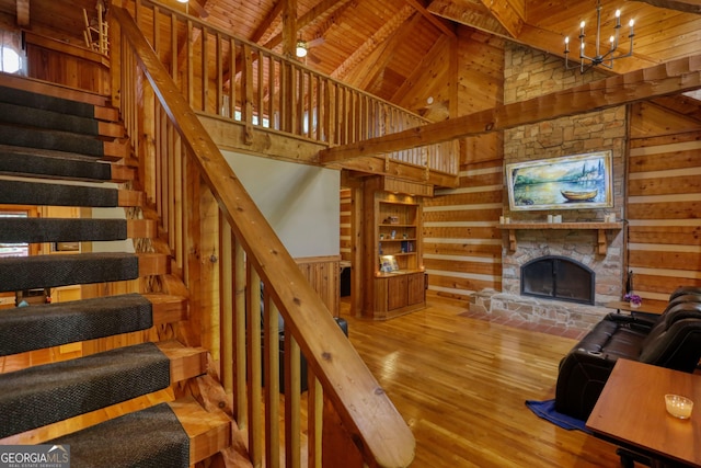 2905 Cammie Wages Rd, Dacula, GA 30019 - living room featuring wooden walls, a chandelier, stairway, high vaulted ceiling, and wood finished floors