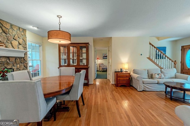 32 N Muscogee Dr, Ellijay, GA 30540 - dining space featuring light wood finished floors, stairs, and a stone fireplace