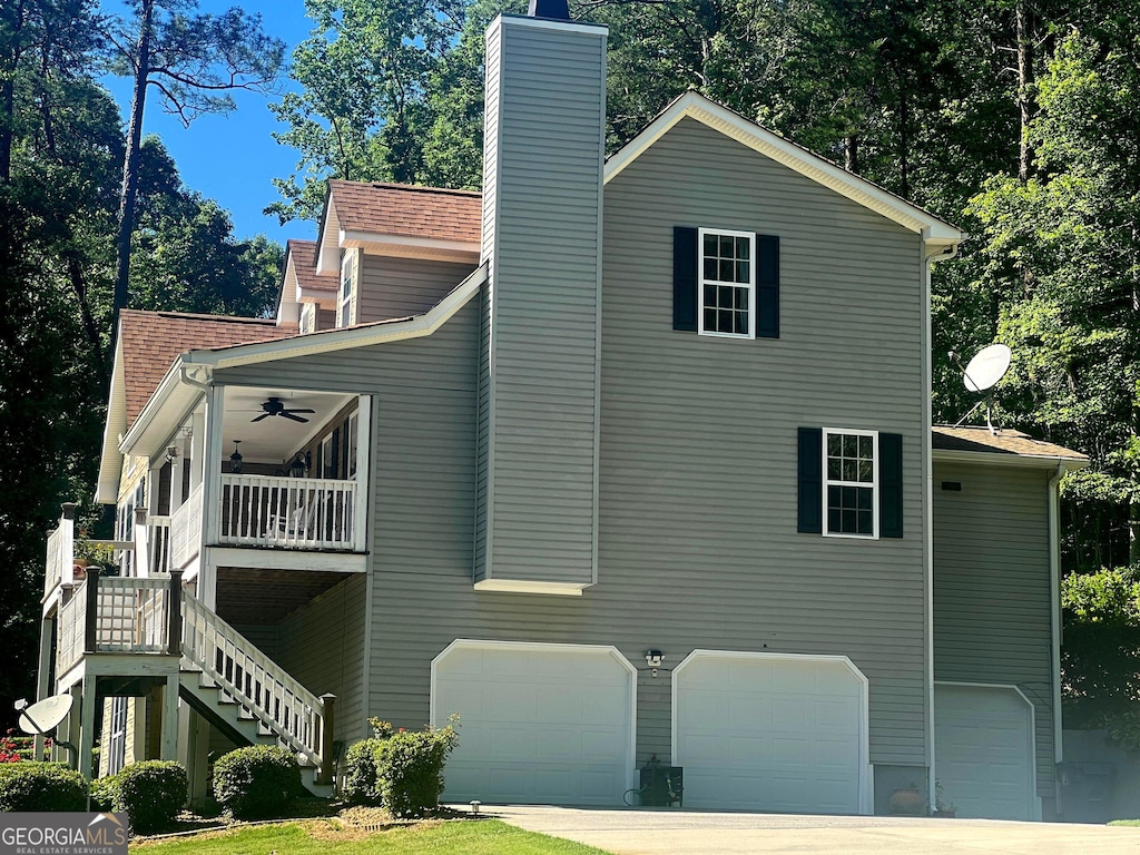 4441 Manning Mill Rd, Summerville, GA 30747 - view of side of home featuring a garage, ceiling fan, stairway, a chimney, and concrete driveway